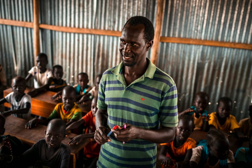 Image of a teacher in a classroom with refugees