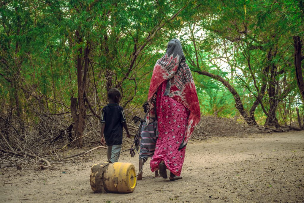 woman and children dragging a jerrycan_fca kenya