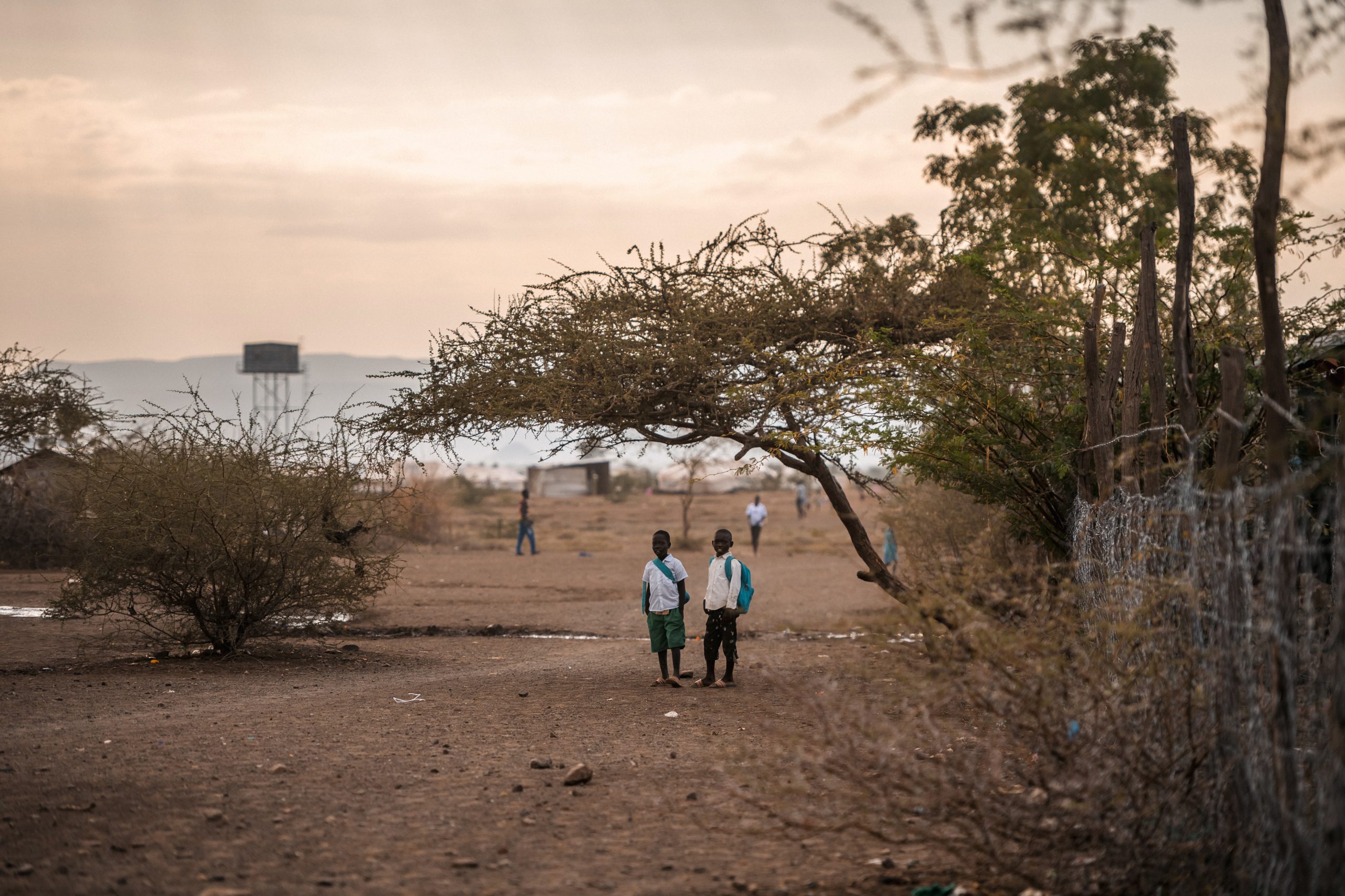 Two boys walking to school in a refugee settlement