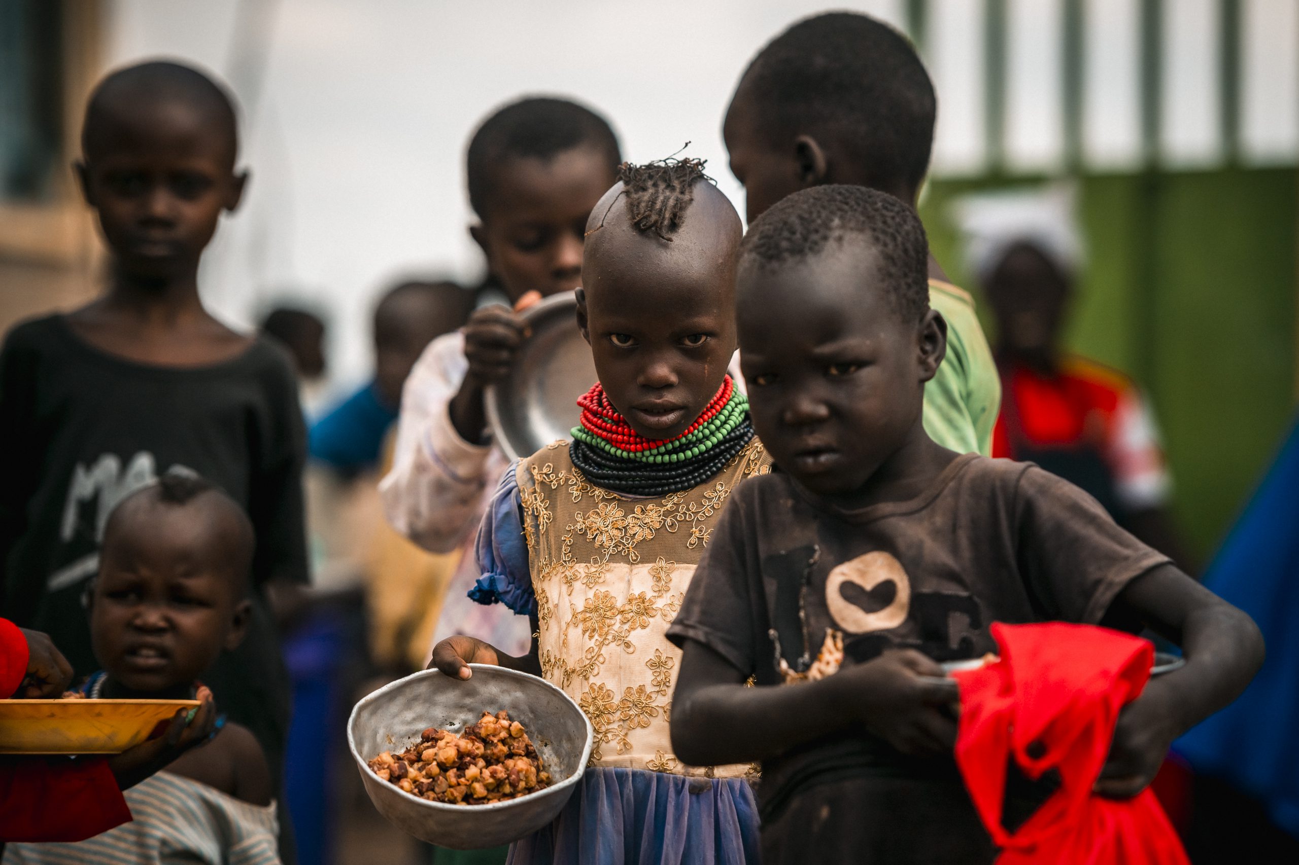 Kenyan children hold bowls of food