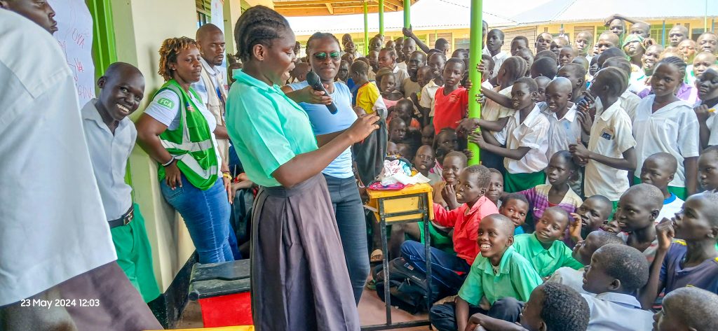 A girl demonstrating how to use a sanitary pad to her peers in one of FCA schools 