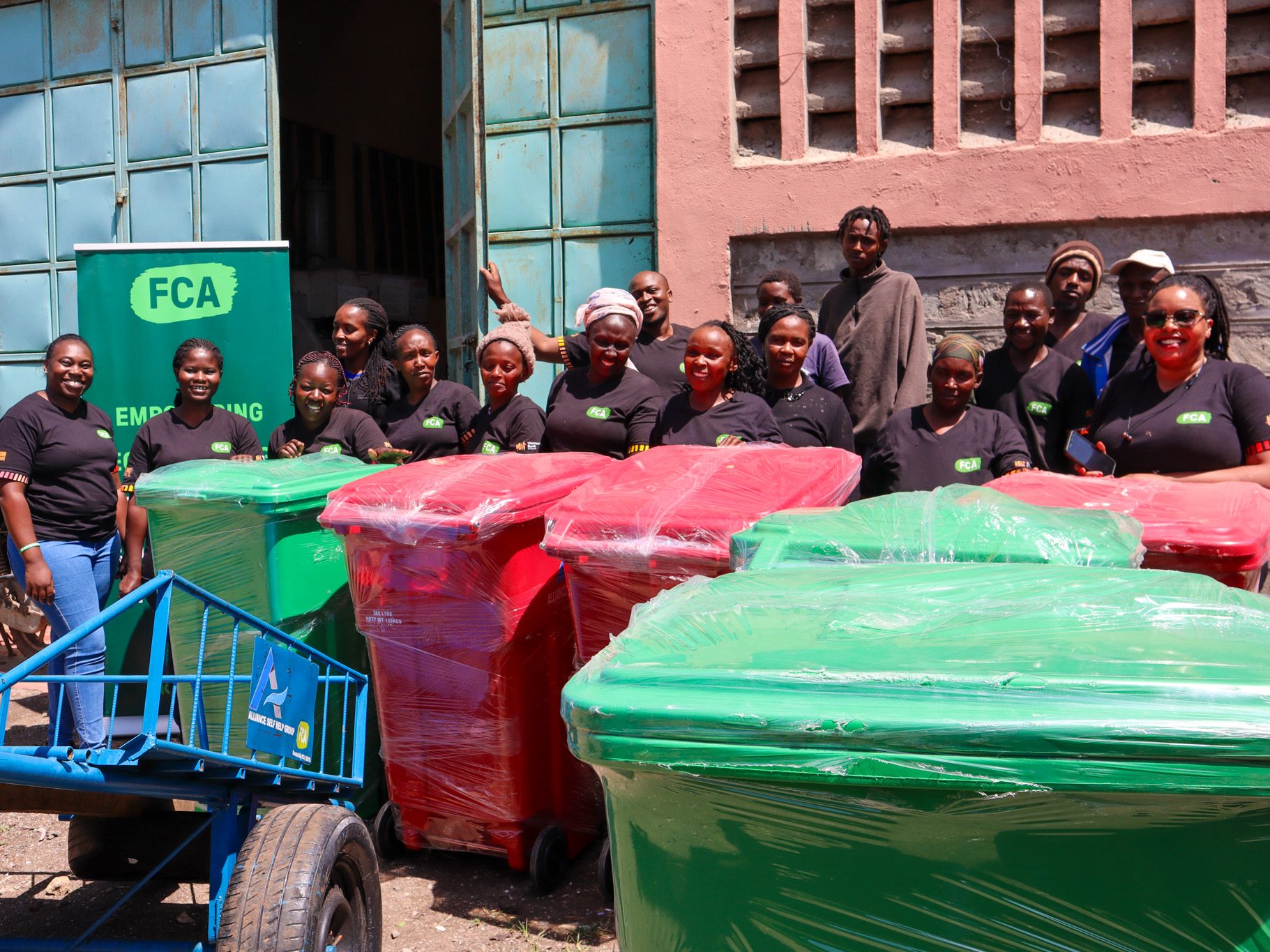 FCA Kenya staff handing over livelihood start up kits to Alliance Self Help Group